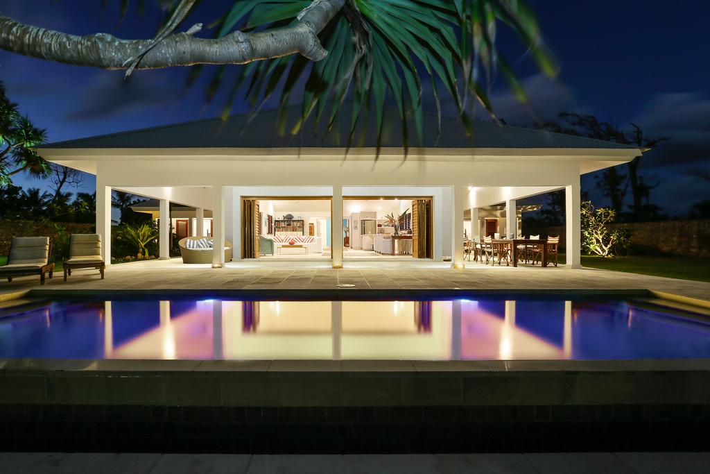 Villa Blanc glowing at dusk beside the pool
